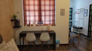 a living room with a table and two white chairs at Rooms only @KKB in Kuala Kubu Bharu