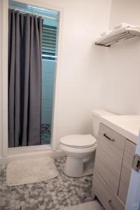 a bathroom with a toilet and a sink and a shower at The Sands Hotel in Cockburn Town +33 photos