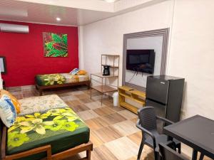 a room with a bed and a table and a tv at Vicina Maris Beach Lodge in María Chiquita