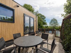 a patio with a table and chairs on a deck at t Sluisje 8 in Bantega