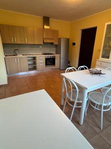 a kitchen with a white table and chairs at GrappoloNero in Laino Castello