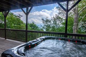 a hot tub on the deck of a house at Pinnacle View Lodge in Boone