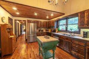 a kitchen with wooden cabinets and a green island in it at Pinnacle View Lodge in Boone +39 photos