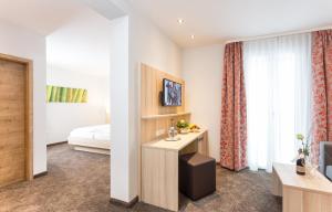 une chambre d'hôtel avec un lit et un bureau dans l'établissement Hotel Pfälzer Wald, à Bad Bergzabern