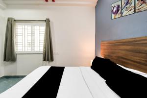 a bedroom with a large bed and a window at Super Townhouse Hitech City Near Yashoda Hospital in Hyderabad +26 photos