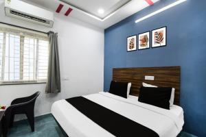 a bedroom with a bed and a blue wall at Super Townhouse Hitech City Near Yashoda Hospital in Hyderabad