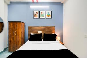 a bedroom with a bed and a blue wall at Super Townhouse Hitech City Near Yashoda Hospital in Hyderabad