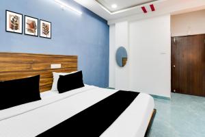 a bedroom with a large bed with a blue wall at Super Townhouse Hitech City Near Yashoda Hospital in Hyderabad