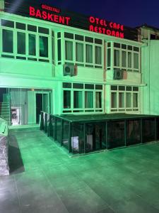 a large building with a green courtyard in front of it at Başkent otel in Mudanya