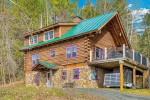 a log cabin with a green roof and a balcony at Wood Road Retreat in Quechee