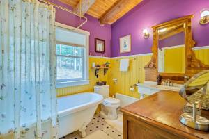 a bathroom with a tub and a toilet and a sink at Wood Road Retreat in Quechee