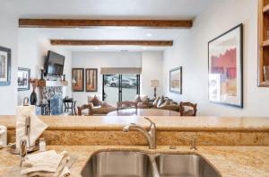 a kitchen with a sink and a living room at Classic Ski-in Ski-out Condo in Park City