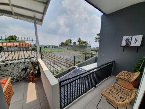 a balcony with two chairs and a view of a field at Kalysandria Home in Padasul