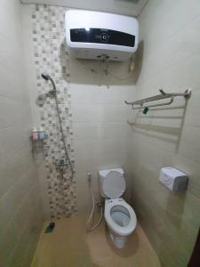 a bathroom with a toilet and a airconditioner on the wall at Kalysandria Home in Padasul +38 photos