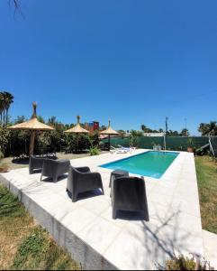 a swimming pool with several chairs and umbrellas next to it at Amanecer Petit in Miramar