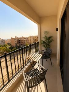 a balcony with a table and chairs and a view of the beach at NOMA New Cairo in New cairo