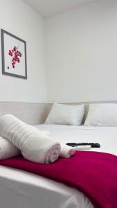 a white bed with a red blanket on it at Repouso Box in Cabo de Santo Agostinho