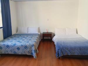 two beds sitting next to each other in a room at Arboleda in Manizales