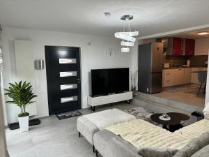 a living room with a couch and a flat screen tv at Modernes Appartment in Schifflange in Schifflange