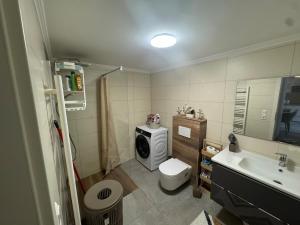 a bathroom with a toilet and a washing machine at Modernes Appartment in Schifflange in Schifflange