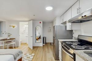 a kitchen with white cabinets and a stove top oven at The Gordon Getaway in Seattle