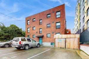 a brick building with a car parked in a parking lot at The Gordon Getaway in Seattle