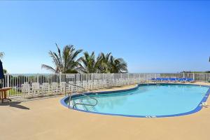 a large swimming pool with chairs and a fence at Carousel 706 in Ocean City