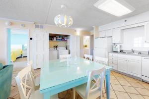 a kitchen with a blue table and white cabinets at Carousel 706 in Ocean City