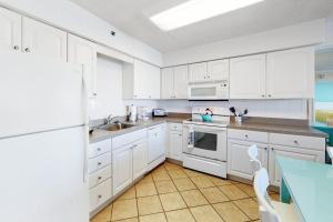 a kitchen with white cabinets and a blue table at Carousel 706 in Ocean City +14 photos
