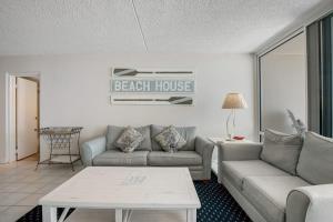a living room with two couches and a beach house sign at Carousel 1605 in Ocean City