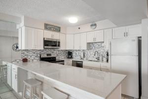 a kitchen with white cabinets and a white refrigerator at Carousel 1605 in Ocean City +34 photos