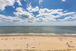 a group of people on a beach near the ocean at English Towers 804 in Ocean City