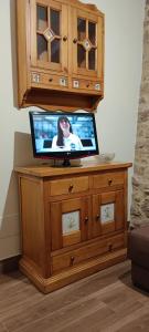 a tv sitting on top of a wooden dresser at El Lagar de Mailusa in Sayar