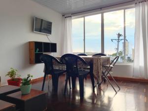 a dining room with a table and chairs and a large window at Arboleda in Manizales +7 photos