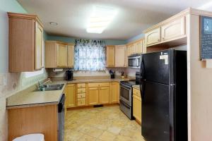 a kitchen with wooden cabinets and a black refrigerator at 604 Seaweed Lane #1 in Ocean City