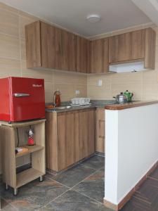 a kitchen with wooden cabinets and a red refrigerator at Arboleda in Manizales