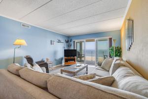 a living room with a large couch and a television at Salty Sands in Ocean City