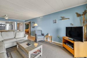 a living room with a couch and a flat screen tv at Salty Sands in Ocean City