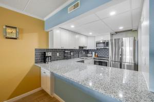 a large kitchen with white cabinets and granite counter tops at Salty Sands in Ocean City +15 photos