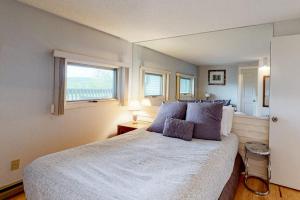 a bedroom with a large white bed with a window at Mountainside Resort B202 in Stowe