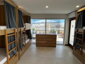 a room with bunk beds and a large window at Central Hostel Malta in Birkirkara