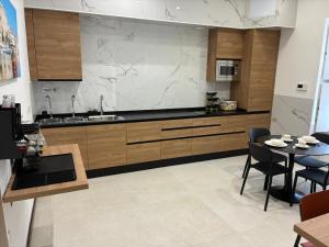 a kitchen with wooden cabinets and a table with chairs at Central Hostel Malta in Birkirkara