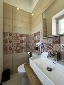 a bathroom with a sink and a toilet and a mirror at Central Hostel Malta in Birkirkara +12 photos