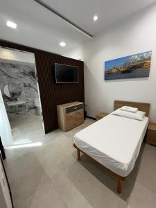a bedroom with a bed and a flat screen tv at Central Hostel Malta in Birkirkara