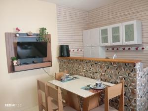a dining room with a table and a tv at Rancho das mangabeiras in Mata de Sao Joao