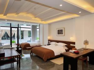 a bedroom with two beds and a desk at Between Trees and Streams in Jiuzhaigou
