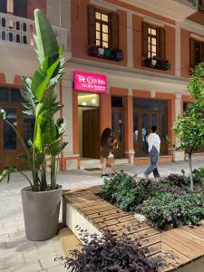 two people walking in front of a building at The cosy inn vlora in Vlorë