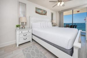 a white bedroom with a bed and a window at Phoenix V 916 in Orange Beach +47 photos