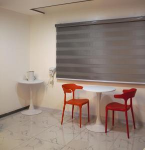 two red chairs and a table in a room at Koregon Hotel in Fort Stotsenburg +79 photos