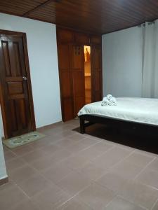 a room with a bed and a door and a floor at La casa de Juana in Las Tablas